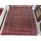 Tribal rugs; an old Turkmen Bokhara dark pink ground rug, finely woven and hand knotted with