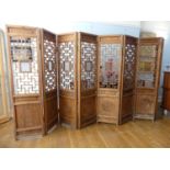 A pair of Chinese late Qing Dynasty four panel folding Screens, the panelled lower section with