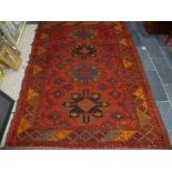 Tribal rugs; an old Caucasian Kazak red ground rug, coarsely woven and hand knotted with date