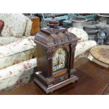 An early 20th century German oak chiming and striking Mantel Clock, with silvered arched dial, black