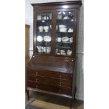 An antique mahogany Bureau Bookcase, the moulded cornice above the two glazed doors each with six