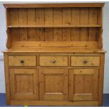 A 20thC pine 'Jersey' Kitchen Dresser, the moulded cornice above planked back with three shelves,