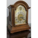 An early 20th century American walnut Mantel Clock, with brass arched dial, silver chapter ring