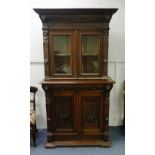 A late Victorian heavily carved oak Cabinet, the glazed top with central motif abve feather effect