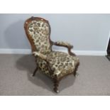 A late Victorian carved walnut open Armchair, with floral upholstery and ceramic casters, 25in (63.