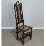 An antique Calolean style walnut side Chair, with caned back and seat, raised on turned and block