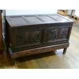 A 17th century and later carved oak Coffer, the associated four-panel hinged lid above carved frieze