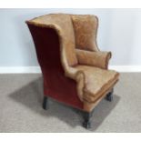 An early 20th century wing Armchair, the upholstered back with lugged sides and outscrolled arms,