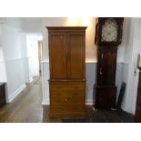 An early 20thC oak Cupboard, the two panel cupboard with shelved interior above a chest of drawers