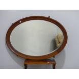An Edwardian mahogany and inlaid framed oval Mirror, the mirror plate with bevelled edge, 33in (