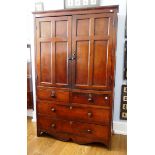 An early 19th century elm Cupboard, the moulded cornice above a pair of paneled doors enclosing