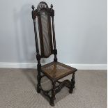 An antique Calolean style walnut side Chair, with caned back and seat, raised on scrolled front legs