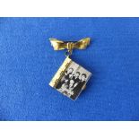 The Beatles, a 1960's gilt metal folding photo album brooch, featuring twelve various photographs of