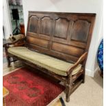 A 19thC oak Settle, with panelled back, believed to be from Trinity College, Cambridge, some