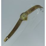 A 9ct yellow gold Tissot lady's Wristwatch, the circular gilt dial with black baton markers, on