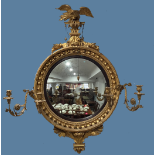 A Regency-style giltwood Girandole Mirror, surmounted with a carved eagle, with circular convex