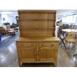 A vintage Ercol Dresser, design 453, with plate rack above two drawers and doors, with sticker label