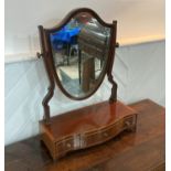 A George III mahogany shield-shaped Toilet Mirror, the bevelled plate above three drawers, 18½in (