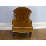 An antique button back Child's Chair, in mustard upholstery, on turned legs, brass caps and castors,