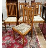 A set of four Arts and Crafts oak Dining Chairs, with drop in seats of mix-matched upholstery,