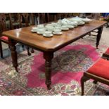 An Edwardian mahogany extending Dining Table, raised on turned legs and brass caps and castors, 88in
