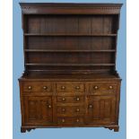 A George III oak Welsh Dresser, the dentile cornice above plate rack, upon three drawers and two