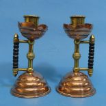 A pair of Arts and Crafts Christopher Dresser-style Candlesticks, in copper and brass with turned