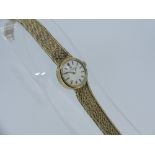 A 9ct yellow gold Omega lady's Wrist Watch, on 9ct textured mesh strap, gross total weight 23.3g.