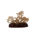 † A CHINESE AGATE 'BIRDS AND PINES' BRUSH REST.