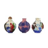 THREE CHINESE OVERLAY GLASS SNUFF BOTTLES.