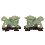 A PAIR OF MODERN CHINESE CARVED PALE GREEN JADEITE LION DOGS