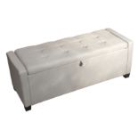 A CONTEMPORARY OTTOMAN STOOL UPHOLSTERED IN GREY FABRIC