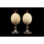 A PAIR OF MID-CENTURY OSTRICH EGGS MOUNTED WITH MEDITERRANEAN CORAL