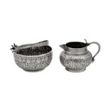 A late 19th century Indian unmarked silver milk jug and sugar bowl with sugar tongs, Lucknow circa 1