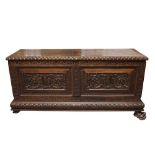 A PROFUSELY CARVED CONTINENTAL CHESTNUT COFFER