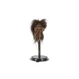 A FAUX SHRUNKEN HEAD ON STAND