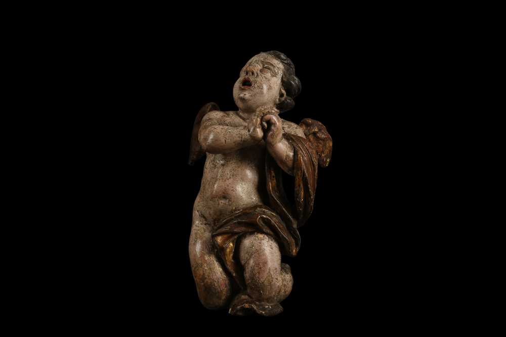 AN EARLY 17TH CENTURY SOUTH GERMAN POLYCHROME DECORATED AND CARVED WOOD FIGURE OF A CHERUB