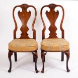 A pair of walnut single chairs with carved shell above the splat back,