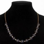 A sapphire and diamond necklace of thirteen flowerhead links interspersed by oval diamond set links,