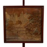 A mahogany pole screen with vase finial, the machine worked panel of a house beside a river,