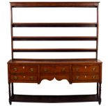 A 19th Century Welsh oak dresser with open rack above a base of five drawers,
