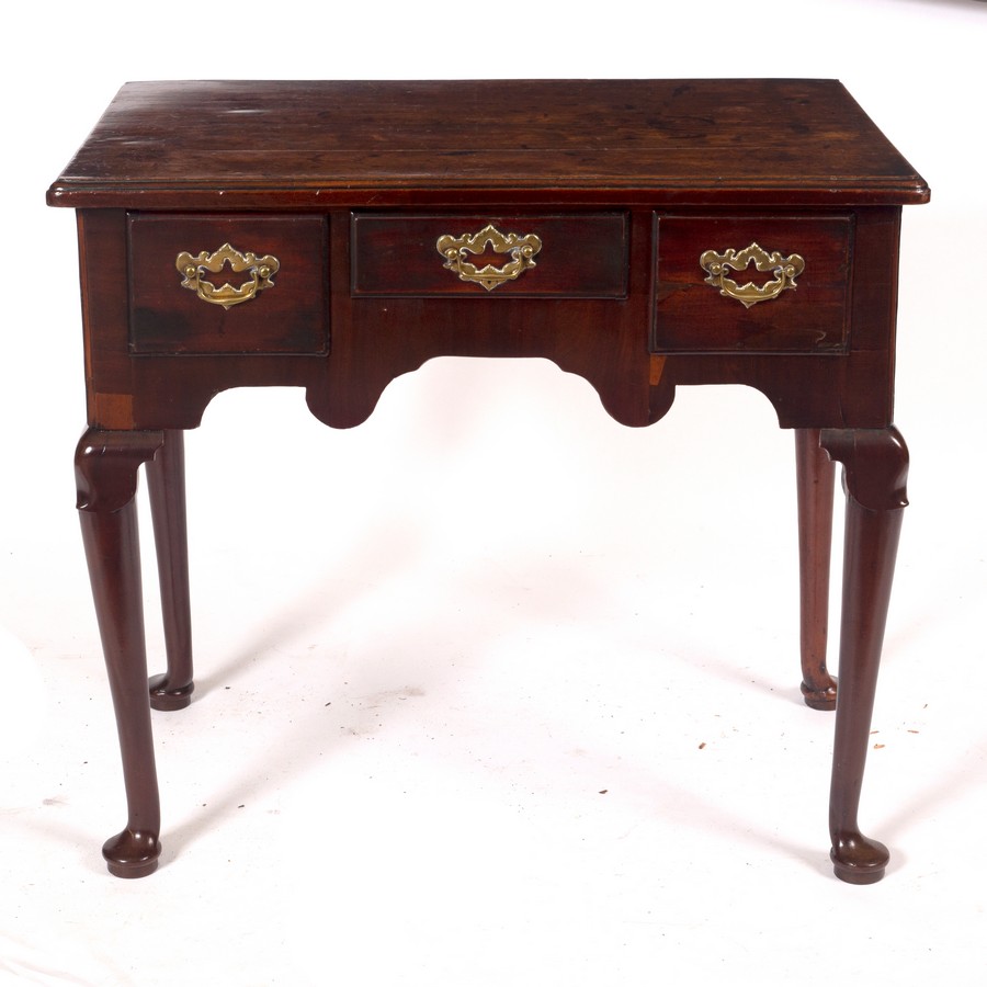 A George II mahogany three-drawer side table, circa 1740, on cabriole legs with pad feet,