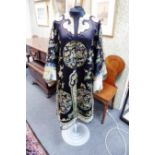 A Chinese mandarin robe, circa 1870, dark blue with roundels of ladies at leisure in gardens,