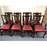 Eight mahogany dining chairs with pierced splat backs and loose trap seats,