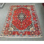 A Hamadan rug, the red ground with central medallion and floral spandrels,