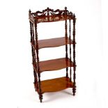 A Victorian mahogany serpentine front whatnot with pierced gallery and turned supports,