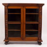 A Victorian rosewood display cabinet enclosed by glazed doors flanked by pilasters, on bun feet,