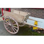 A builders' cart, the flat bed with plank sides and two steel rimmed fourteen spoke wheels,