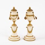 A pair of gilt metal mounted garniture vases each modelled as an urn on a circular swaged plinth,