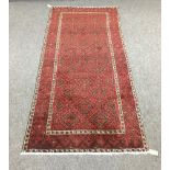 A Baluchi rug, the red ground with all over geometric field,